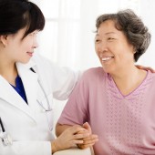 Nurse holding hand of senior woman in rest home